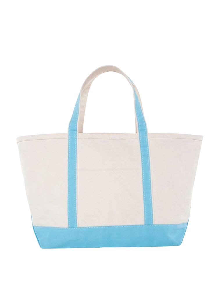 A canvas boat tote with a navy blue base and white upper part, featuring two handles and a front exterior pocket.