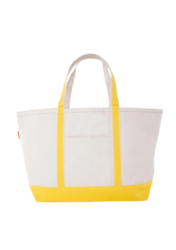 A canvas boat tote with a navy blue base and white upper part, featuring two handles and a front exterior pocket.