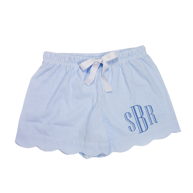 A pair of women's seersucker scallop lounge shorts in blue with a white drawstring waistband, displayed against a white background.