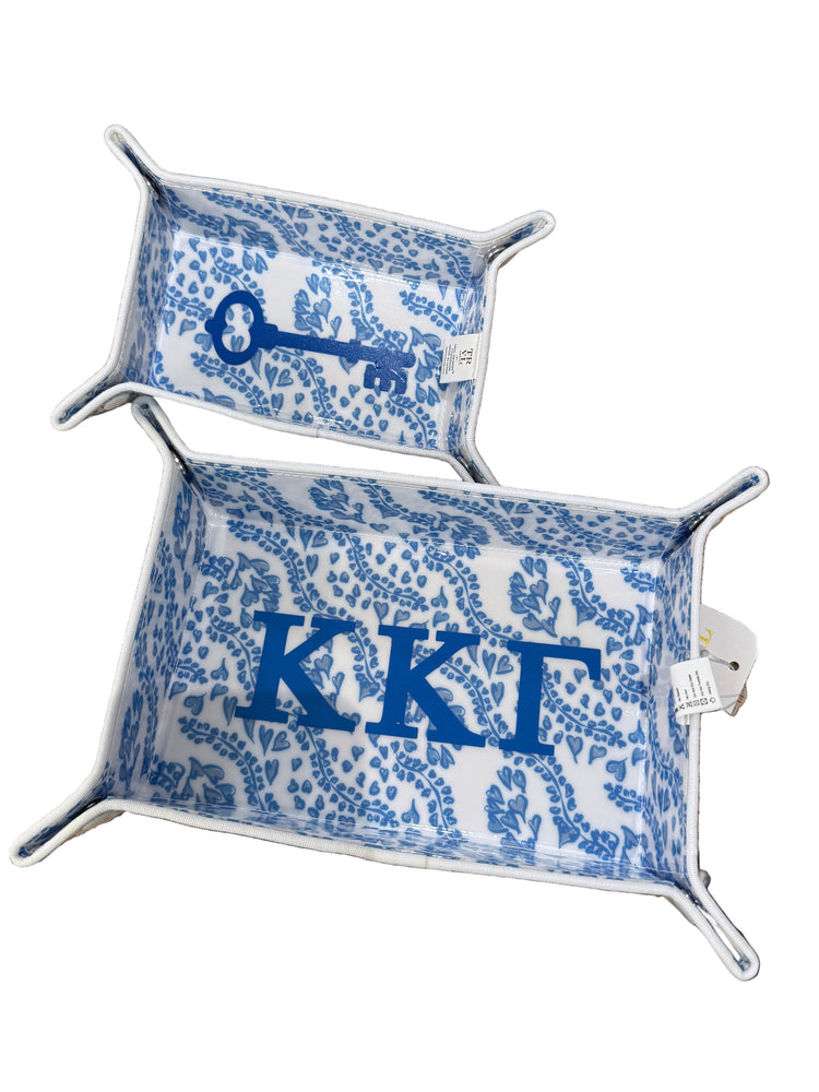 Two decorative trays with blue lettering and key design on a textured surface