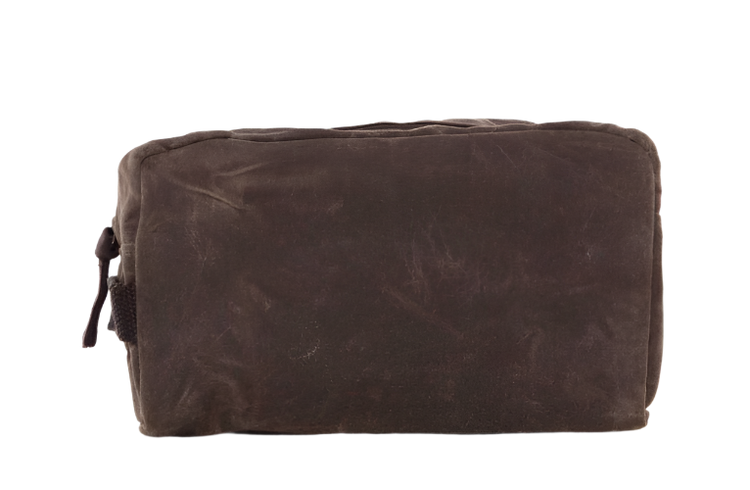 A waxed canvas travel kit in olive green with a top zip closure and side handle.