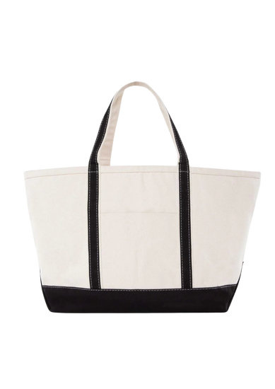 A canvas boat tote with a navy blue base and white upper part, featuring two handles and a front exterior pocket.