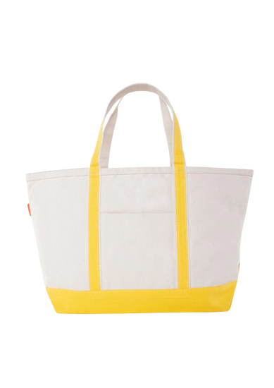 A canvas boat tote with a navy blue base and white upper part, featuring two handles and a front exterior pocket.