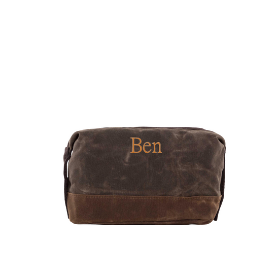 Brown toiletry bag with 'Ben' embroidery on a white background