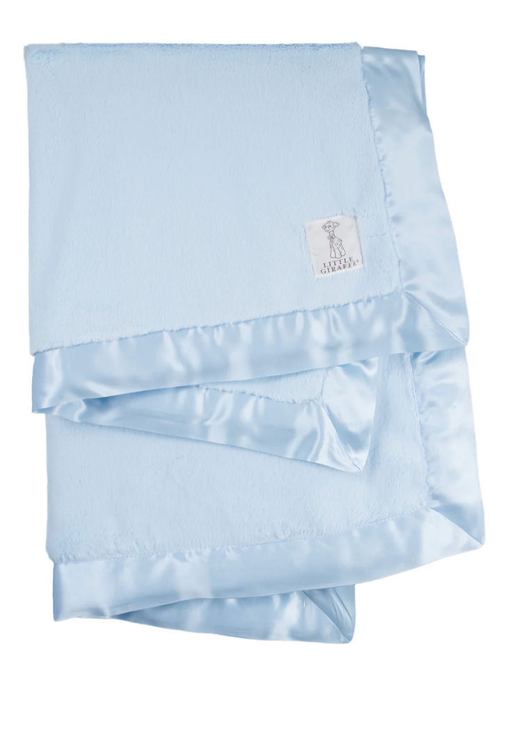 A blue baby blanket with a satin border and a small white label with a logo on the lower side.