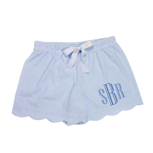 A pair of women's seersucker scallop lounge shorts in blue with a white drawstring waistband, displayed against a white background.