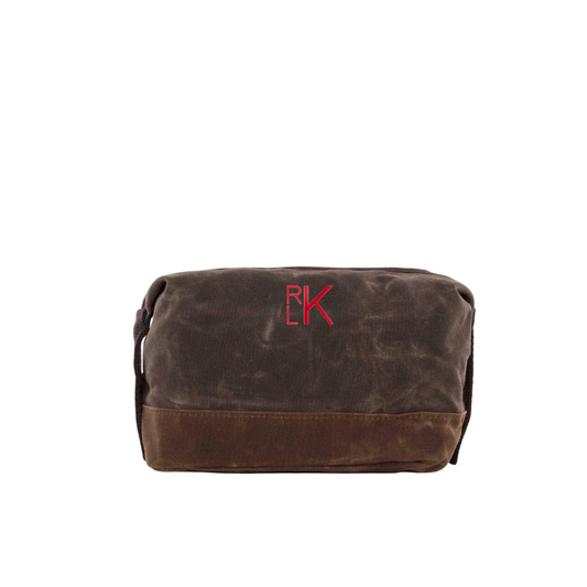 Brown toiletry bag with a red logo on a white background